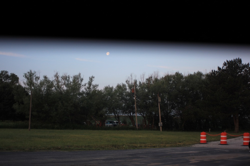 partially obstructed photo of moon over field